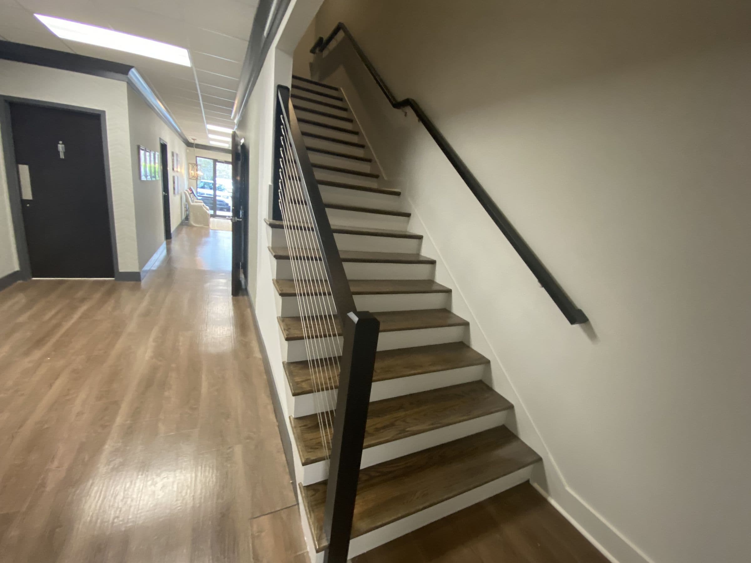 Commercial stair with wood treads and a black cable rail