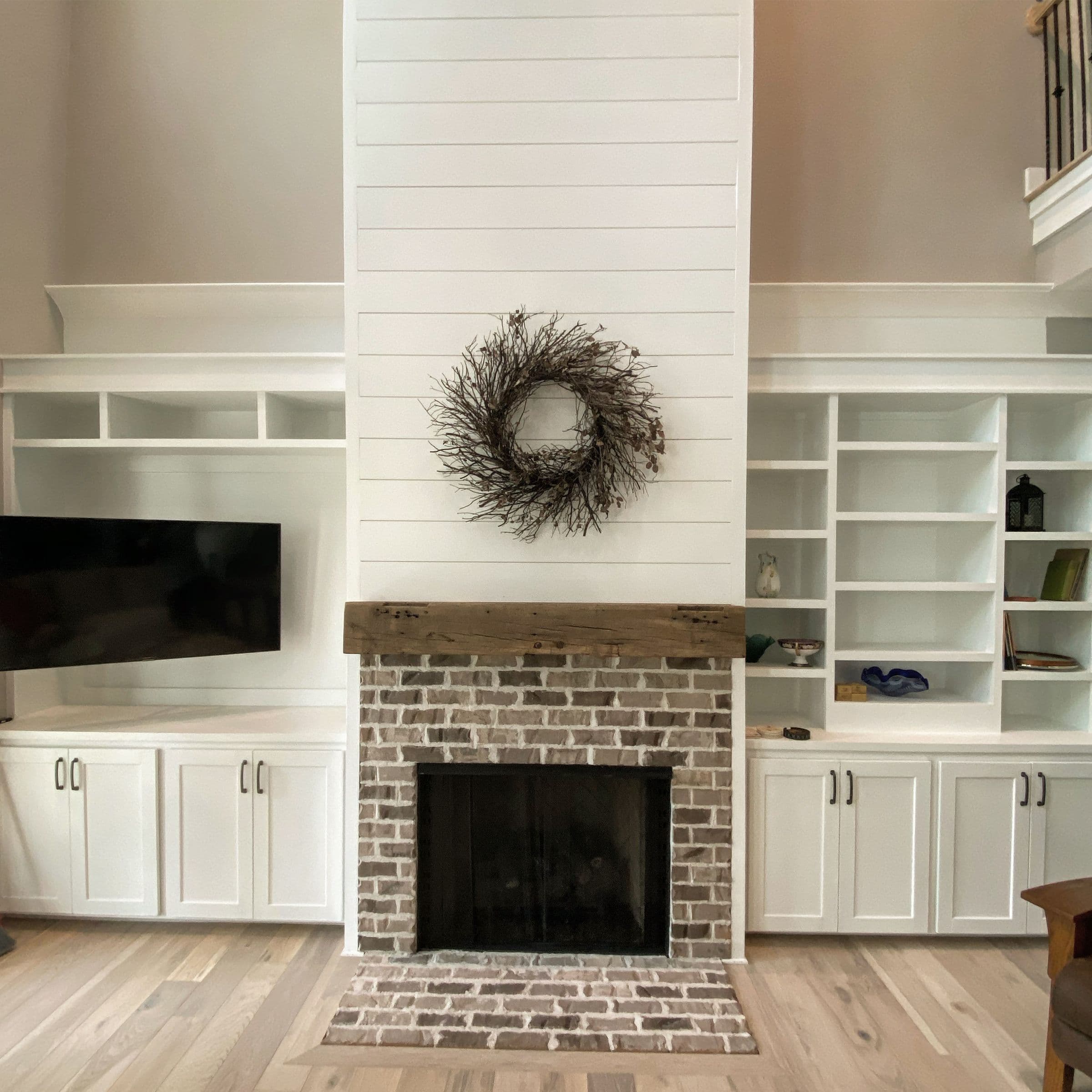 Shiplap chimney with brick fireplace and built-in cabinets on both sides