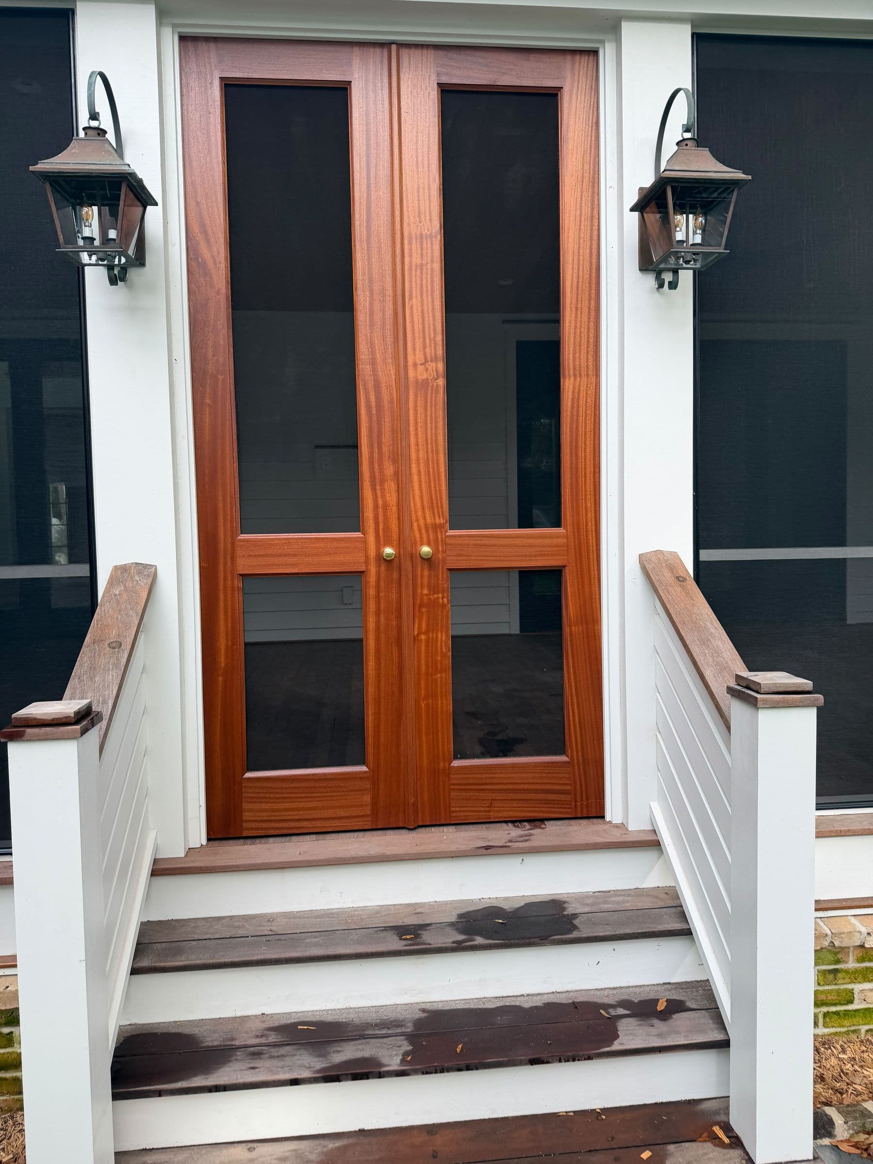 Mahogany double screen doors between gas lanterns
