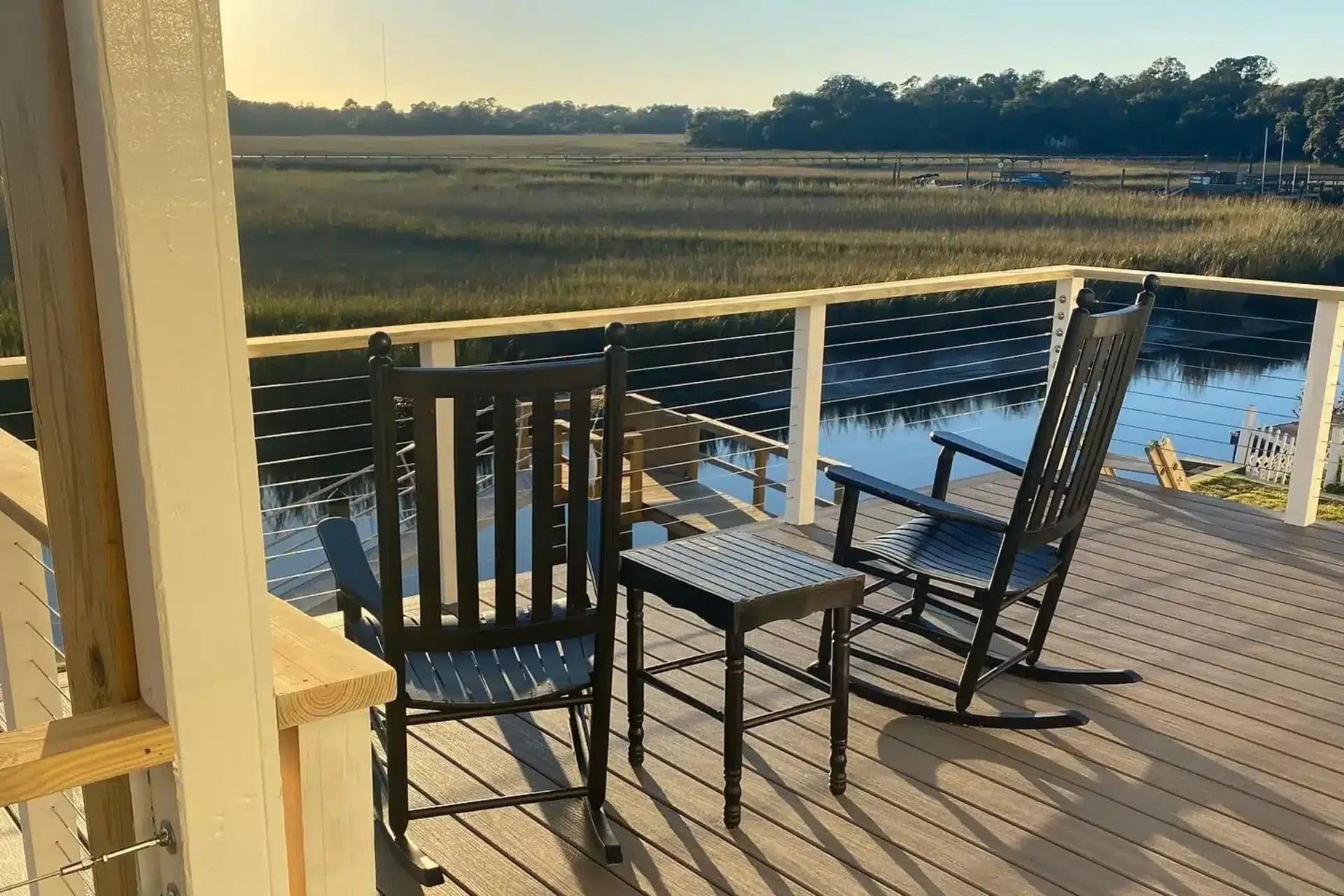 Deck with cable railing and rocking chairs overlooking the marsh