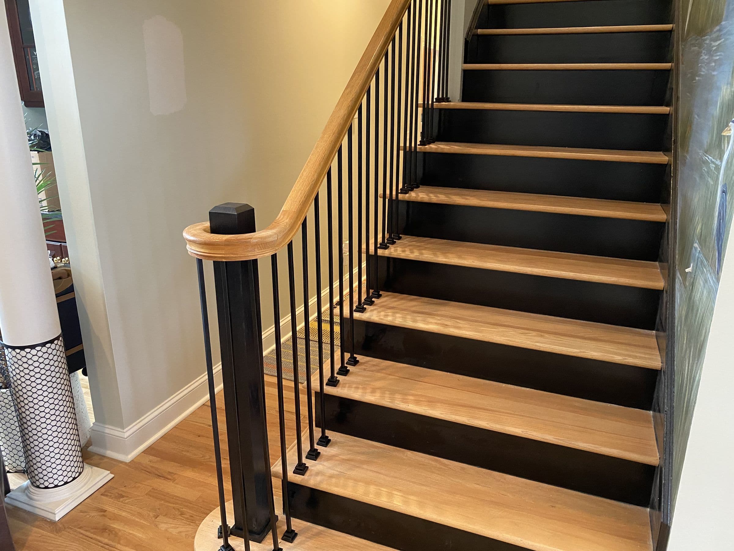 Interior stair with oak treads, black risers and iron balusters